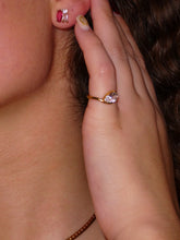 Load image into Gallery viewer, Model wearing the Liora gold-plated stainless steel ring with a clear pear-cut cubic zirconia on her pinky finger.