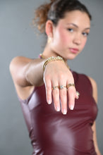 Load image into Gallery viewer, Model wearing the Valeria Crystal Band Ring with coordinating gold rings and bracelets.