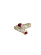 Load image into Gallery viewer, Gold-plated 925 sterling silver crossover ring featuring clear pavé moissanite and two red moissanite stones.