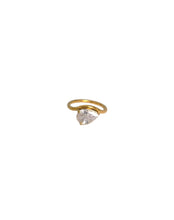 Load image into Gallery viewer, Liora pear-cut cubic zirconia ring styled on a model with gold jewelry.
